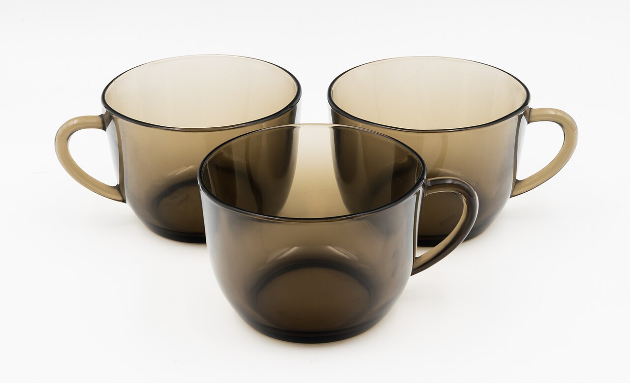 Trois tasses en verre fumé posées côte à côte sur fond blanc.