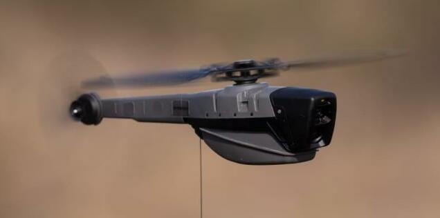 Petit drone de reconnaissance Black Hornet en vol, gros plan latéral sur l’appareil.